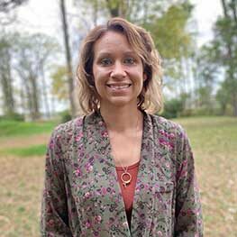 Female dental team member smiling outdoors in a staff profile photo
