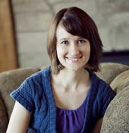 Female dental staff member seated and smiling in a professional photo