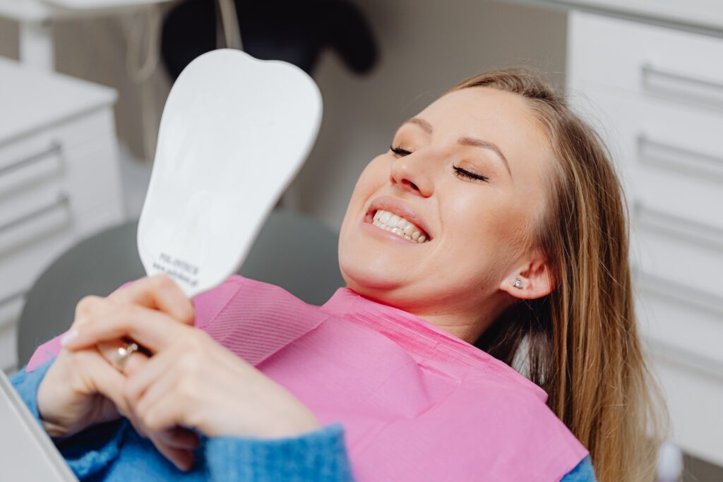 Patient smiling while looking at her smile during a dental appointment.